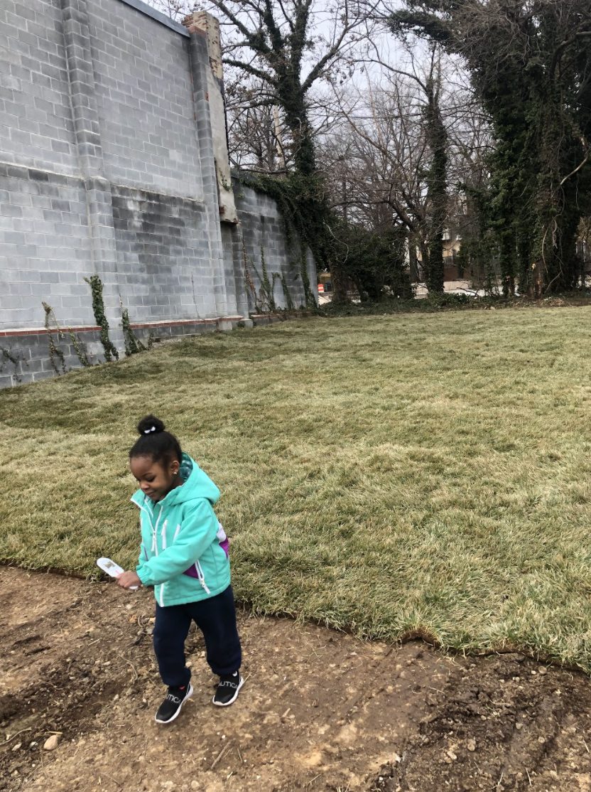 Little girl running in new green space